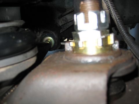 1996 Ford Bronco - Detail of a vehicle's suspension system, focusing on a nut and bolt mechanism.