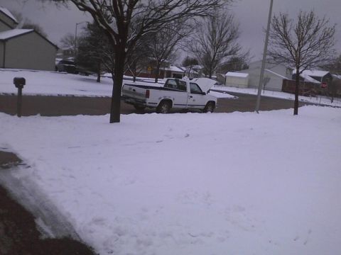 2003 Ford Crown Victoria - A white pickup truck sits on a snow-covered road with its hood open.