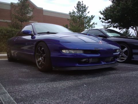 1993 Ford Probe - A blue sports coupe is parked in a lot, with another similar vehicle visible behind it.