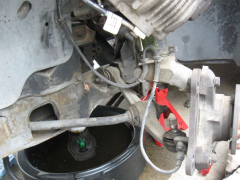 1992 Ford Taurus - Car suspension work in progress, with a drain pan collecting fluid.