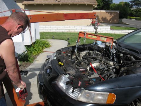 1992 Ford Taurus - Engine hoist attached to a 1992 Ford Taurus as the engine is being removed.