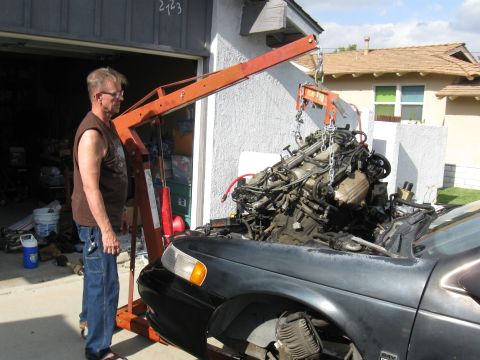 1992 Ford Taurus - An engine is being lifted out of a car with an engine hoist.