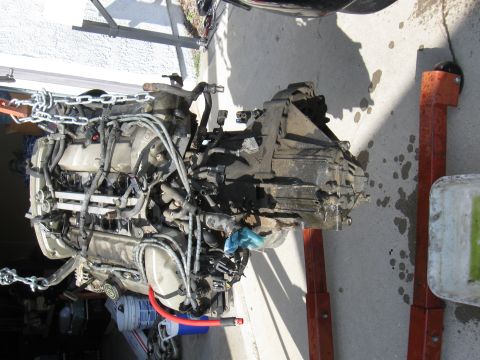 1992 Ford Taurus - Engine and transmission assembly, likely removed from a vehicle, is supported by engine stands.