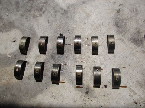 1992 Ford Taurus - Engine bearings are shown on a gray surface, some exhibiting oil residue.