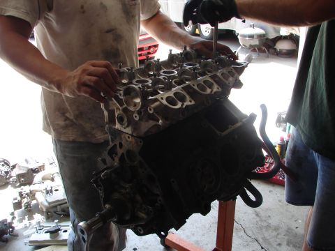 1992 Ford Taurus - Mechanics work on an engine block, likely during a rebuild or repair process.