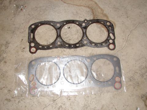 1992 Ford Taurus - A used and a new engine gasket are shown on a concrete surface.