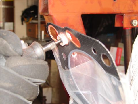 1992 Ford Taurus - Close-up of an engine gasket being fitted with a bolt and washer.