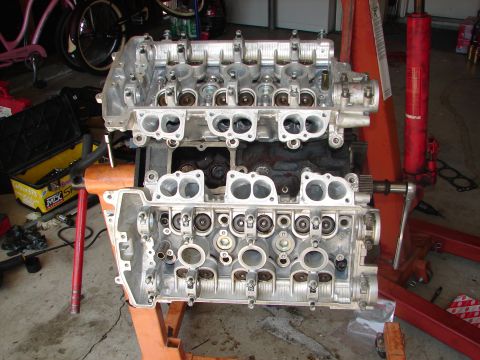 1992 Ford Taurus - Disassembled engine components are shown on an engine stand in a garage setting.