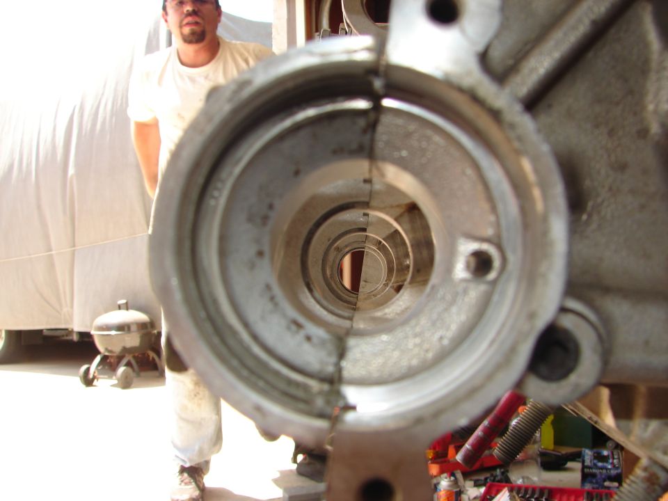 Close-up of an engine block's internal passage, with a person standing in the background