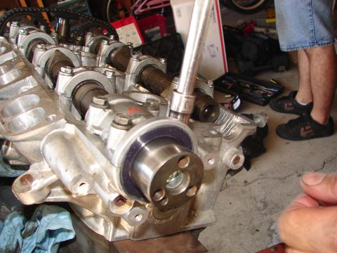 1992 Ford Taurus - Close-up of an engine part with a tool being applied to a bolt.