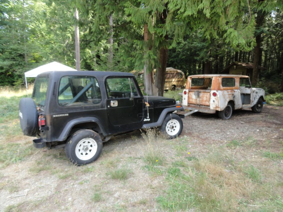 Rusty 1962 International Scout 80 being towed by a black Jeep Wrangler