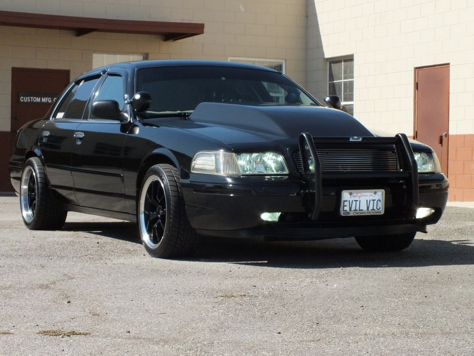 Black Crown Victoria front three-quarter on black wheels with push bar, EVIL VIC plate