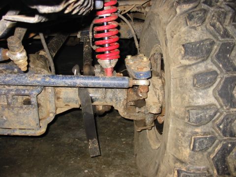1994 Ford Bronco - The suspension system of a off-road vehicle is shown in detail, covered in mud.