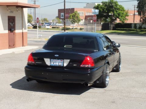 2003 Ford Crown Victoria - Rear of a black Crown Victoria displaying SVT badge and California plate reading EVIL VIC.