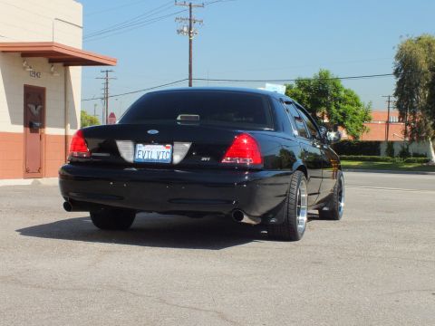 2003 Ford Crown Victoria - Rear three-quarter of a black Crown Victoria with SVT badge and EVIL VIC California plate.