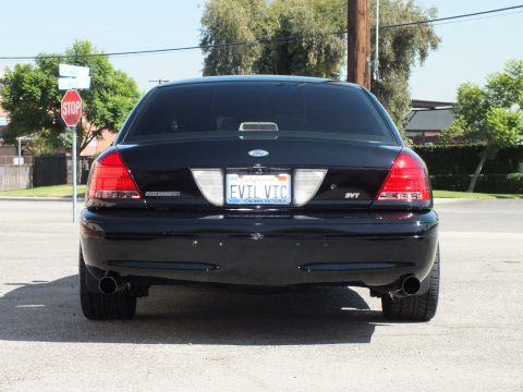 2003 Ford Crown Victoria - Rear of a black Crown Victoria with SVT badge and EVIL VIC plate beside a stop sign.