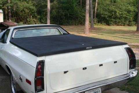 1976 Ford Ranchero - Rear view of a white 1976 Ford Ranchero a black bed cover and prominent "FORD" badging.
