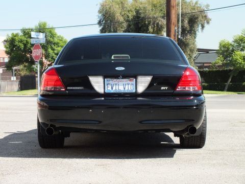 2003 Ford Crown Victoria - Rear view of a black Crown Victoria sedan with dual exhaust, SVT badge and EVIL VIC plate.