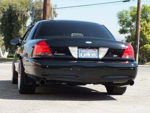 2003 Ford Crown Victoria - Rear view of a black Crown Victoria with dual exhaust tips, SVT badge and EVIL VIC California plate.