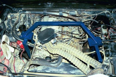 1994 Ford Bronco - Engine bay view showing a blue strut bar installed over the engine components.