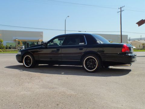 2003 Ford Crown Victoria - Full side profile of a lowered black four-door sedan with dark window tint and black rims.