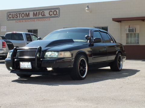 2003 Ford Crown Victoria - Front quarter of a black sedan with chrome grille guard; vanity plate reads EVIL VIC.