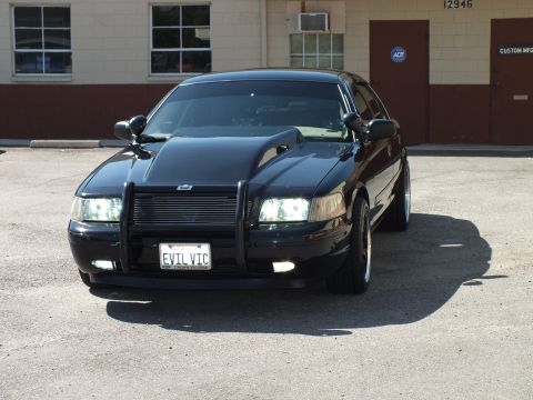 2003 Ford Crown Victoria - Front view of a black sedan showing billet grille, push bar and an EVIL VIC vanity plate.