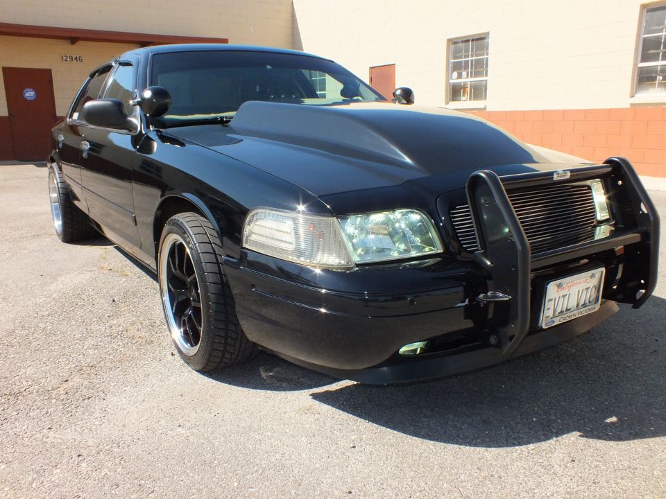 Black Ford Crown Victoria front quarter, push bar and front license plate reading EVIL VIC