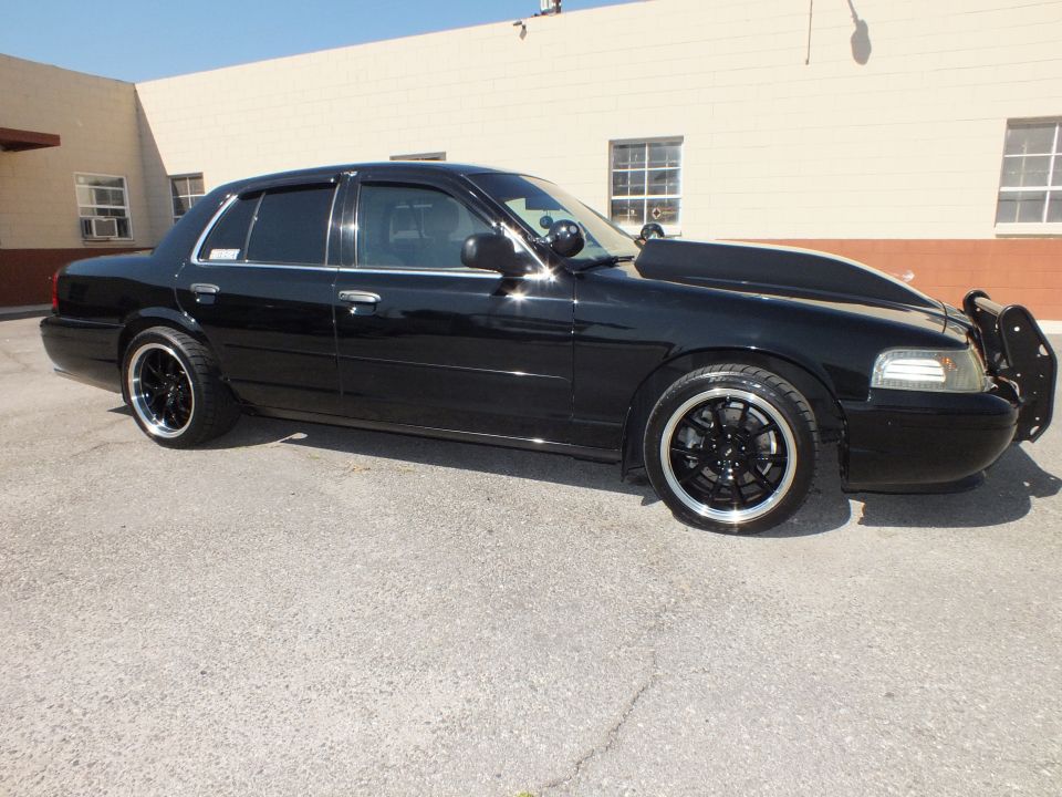 Black Crown Victoria sedan side and front view showing push bar and lowered stance