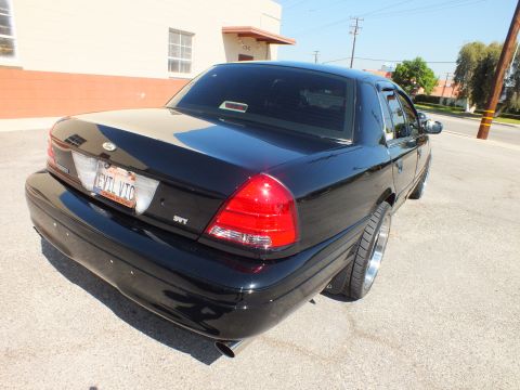 2003 Ford Crown Victoria - Rear three-quarter of the black Crown Victoria showing an SVT badge, dual exhaust and EVIL VIC plate.