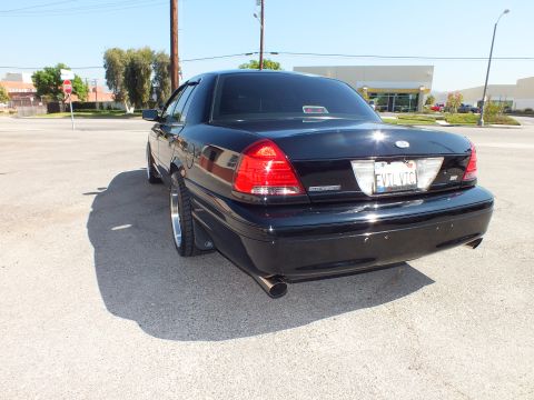2003 Ford Crown Victoria - Rear-quarter view of the lowered black Crown Victoria with chrome exhaust tip and SVT badge.
