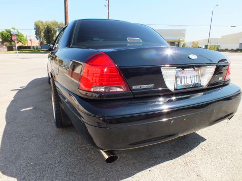 2003 Ford Crown Victoria - Rear-quarter of the black Crown Victoria, Ford oval and SVT badging above the EVIL VIC plate.