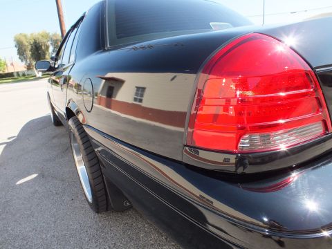 2003 Ford Crown Victoria - Detail of the black Crown Victoria's clear-lens taillight and glossy rear fender.