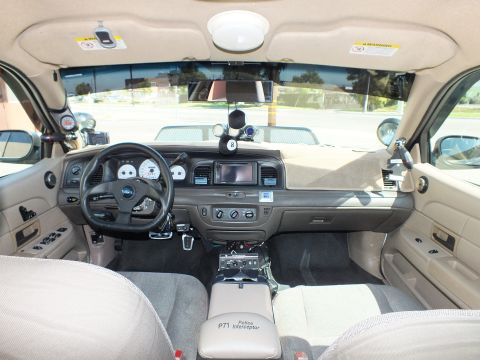 2003 Ford Crown Victoria - Interior view showing the tan dash and a center armrest embroidered P71 Police Interceptor.