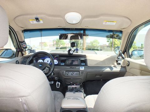 2003 Ford Crown Victoria - Cabin shot from the rear seat; tan trim and the P71 Police Interceptor armrest between front seats.