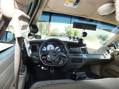 2003 Ford Crown Victoria - Driver-side view showing a sport wheel, pillar-mounted gauge and a pistol-grip shifter.