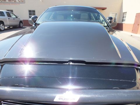 2003 Ford Crown Victoria - Close view down the black hood and cowl, side mirrors flanking a front plate frame.