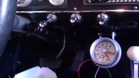 1964 Ford Fairlane - Close-up of a car's interior, focusing on the dashboard and an aftermarket tachometer.