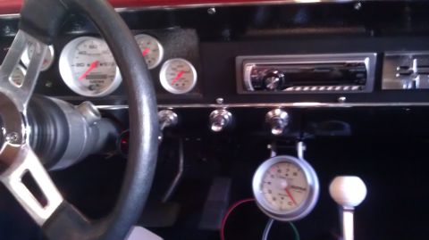 1964 Ford Fairlane - The interior of a 1964 Ford Fairlane shows a custom dashboard with aftermarket gauges and a radio.