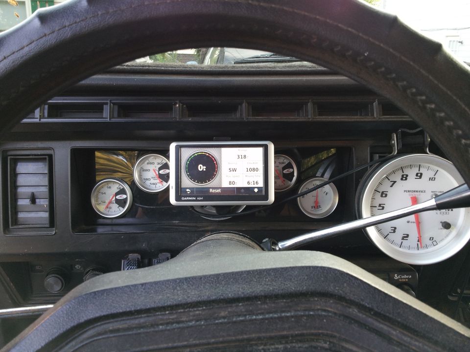 Dashboard interior with multiple gauges, a Garmin GPS, and a tachometer