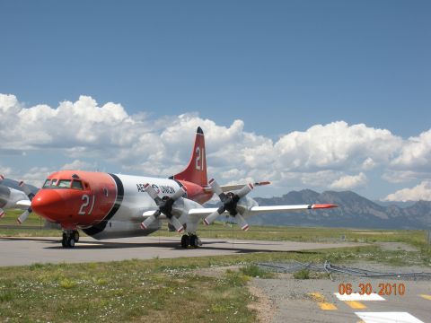 1996 Ford Bronco - A four-engine turboprop aircraft, marked with the number 21, sits on an airfield with mountains in the background.
