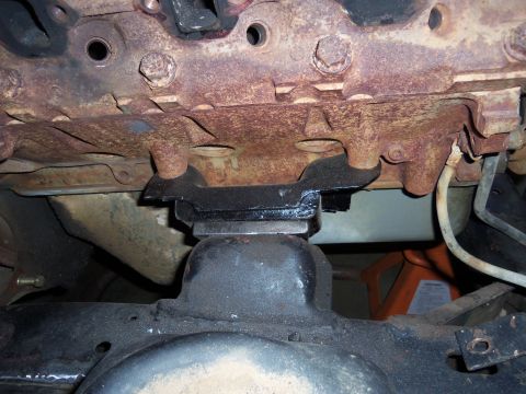 1968 Ford Bronco - Close-up view of a heavily rusted engine block and its mounting hardware.