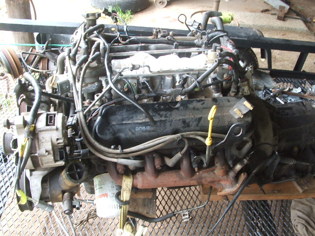 Engine assembly with wiring harness and oil filter. Part number 6069 visible on valve cover