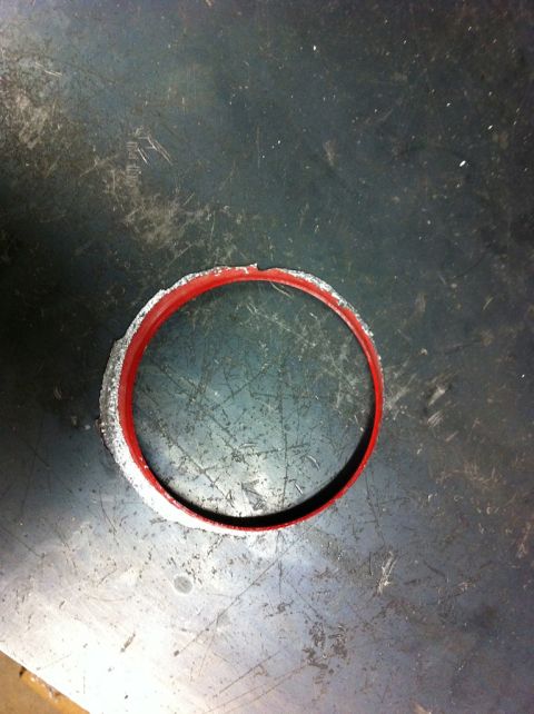 2010 Dodge Challenger - A red gasket with a rough, worn edge sits on a scratched metal surface, possibly a workbench.