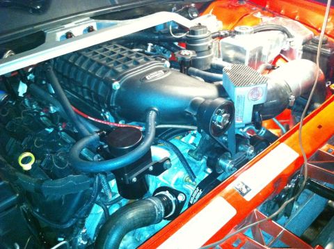 2010 Dodge Challenger - Close-up of a supercharged engine bay, showing various components and custom modifications.