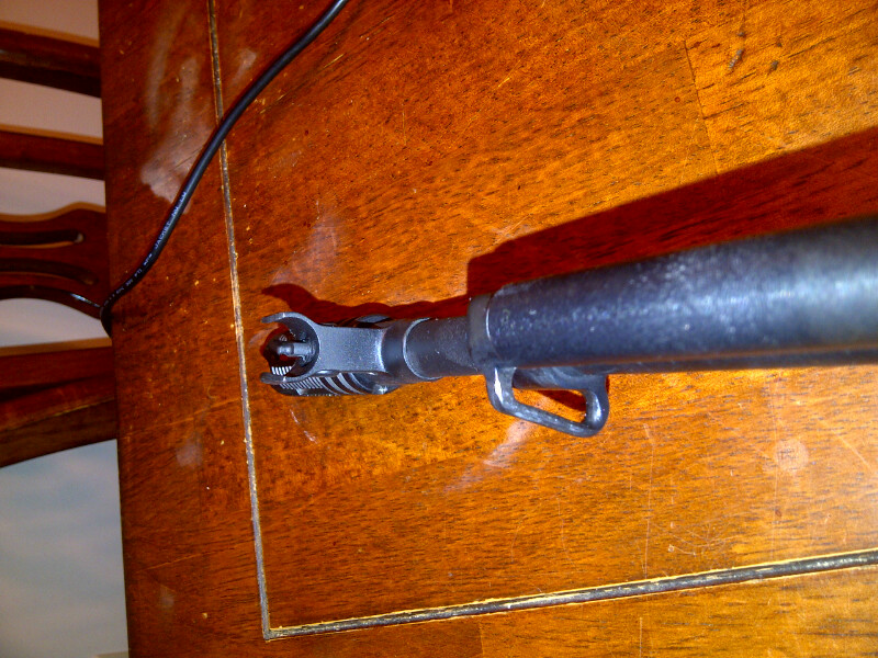 SKS rifle front sight assembly and gas block on wooden surface