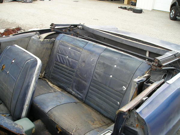 1966 Ford Fairlane convertible interior with worn blue seats and visible damage