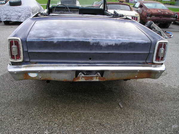 Dark blue 1966 Ford Fairlane convertible rear view with rusty bumper
