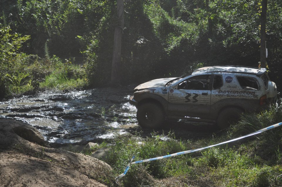 1999 Isuzu Vehicross stuck in a muddy off-road course, with 'Darrington Off-Road' decals visible