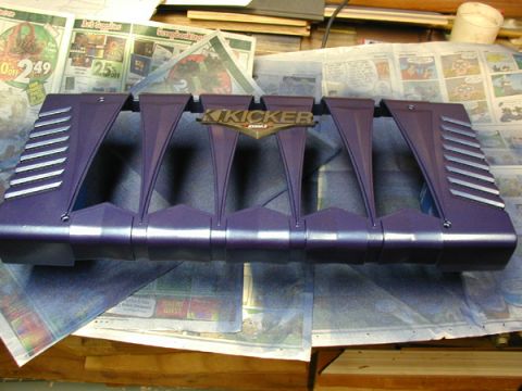1998 Ford Taurus - A Kicker amplifier cover is shown, resting on a surface covered with newspapers.